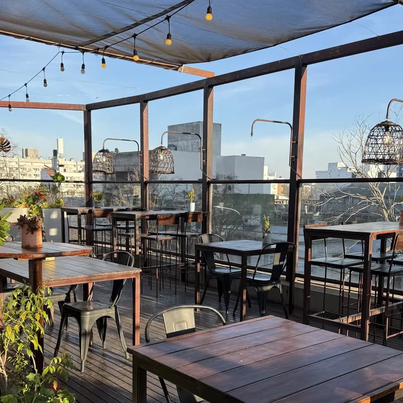Terraza de Confitería San Luis con mesas, guirnalda de luces y vista panorámica de La Plata